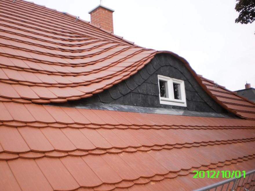 Detail einer handwerklich ausgeführten Biberschwanzdeckung und Gaube